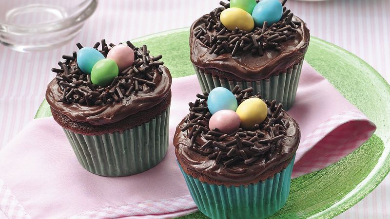 cupcakes decorated to look like a bird's nest with chocolate sprinkles as the nest and chocolate eggs