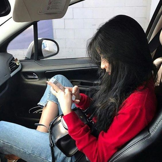 Girl shopping on her phone in the car