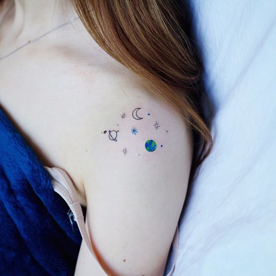 Asian girl with a colourful, small and minimalist shoulder tattoo of constellations, planets and stars