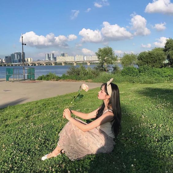 Asian girl spending time in nature and holding a rose