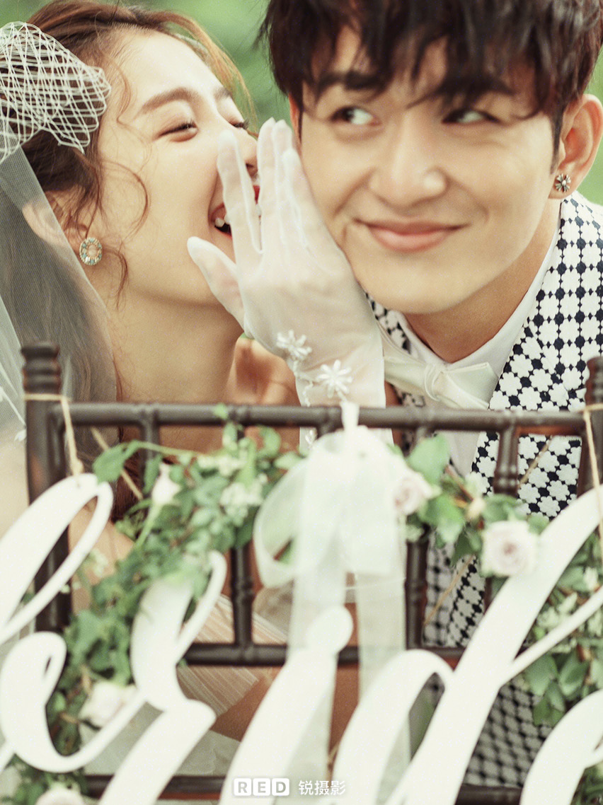 Bride whispering into groom's ear