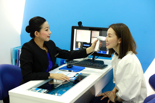 Staff at New York Skin Solutions helping Yvonne Lim check her skin condition