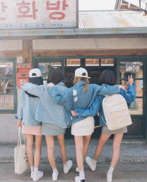 Girl friends wearing matching denim jackets and going shopping together