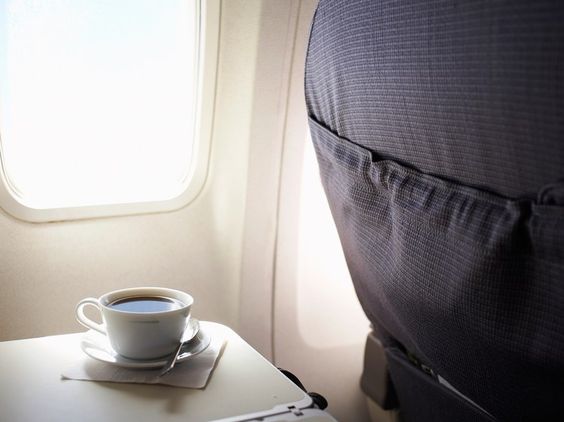 a cup of tea on a tray in a plane