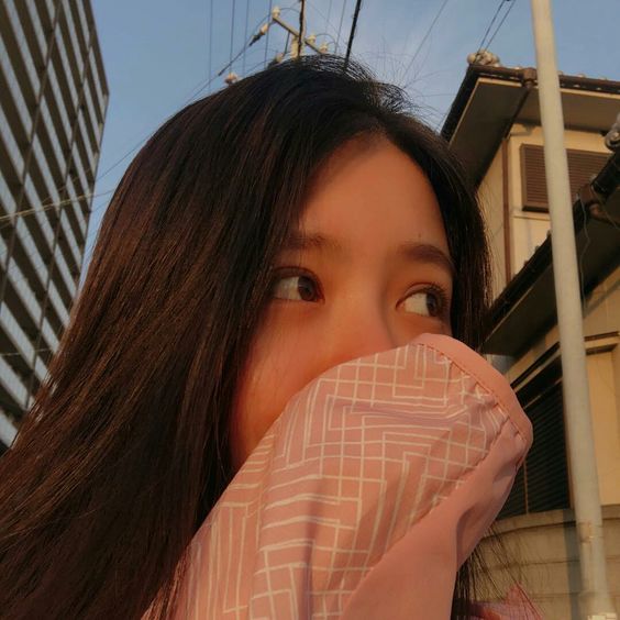 girl shielding mouth