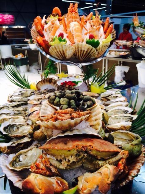 buffet with assorted seafood dishes like crab, oyster, sashimi, clams