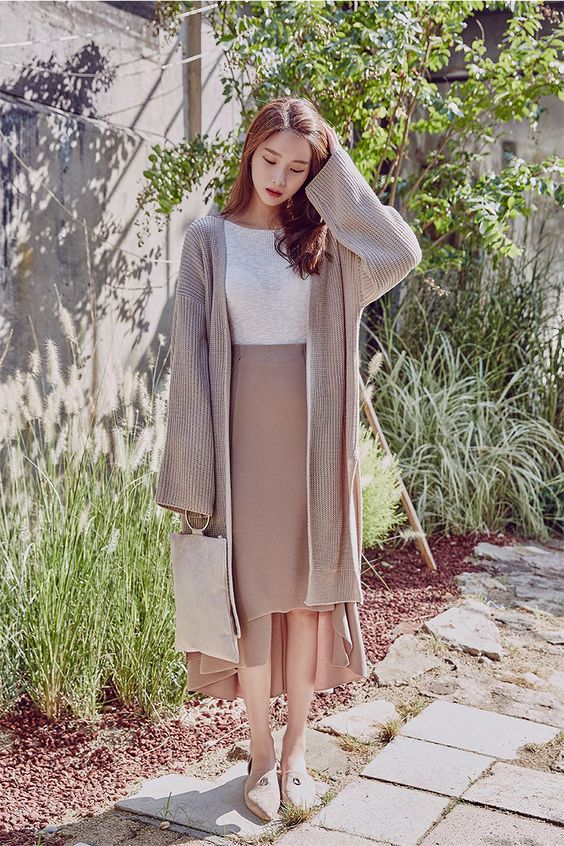 asian woman wearing a long cardigan and high waisted skirt