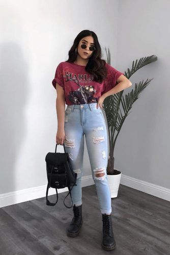 girl wearing band tee, jeans, sunglasses and a backpack