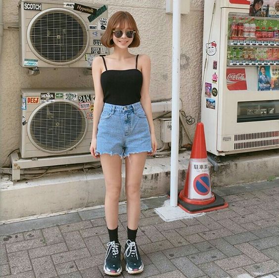 girl wearing a top, denim shorts and sneakers