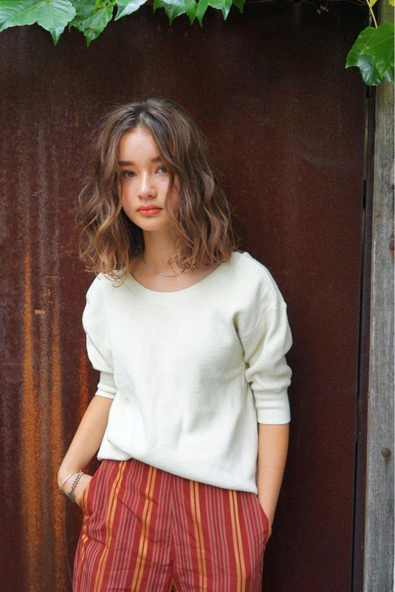 asian girl with an Airy textured bob with loose waves and a middle parting