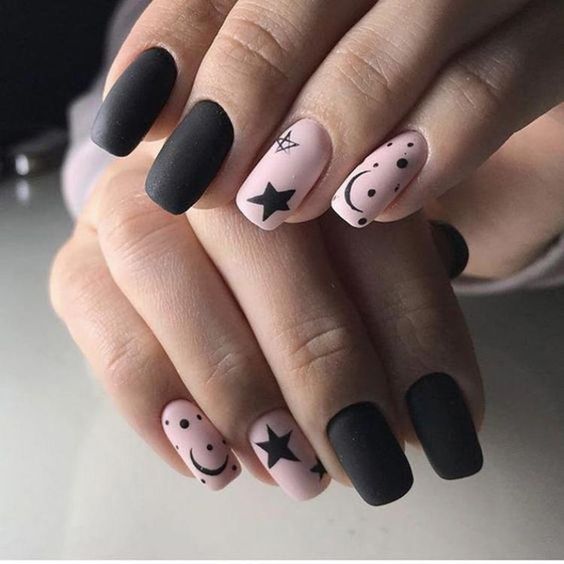 Matte minimalist gothic nails in black and pink with constellations like moon and stars
