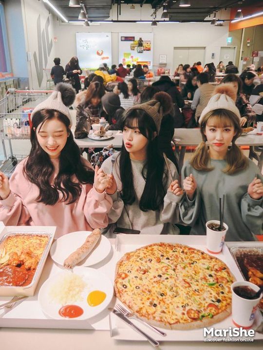 3 girl friends wearing matching outfits eating pizza