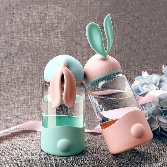two water bottles with bunny ears in pink and green