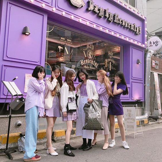 group of asian friends posing in front of a purple restaurant