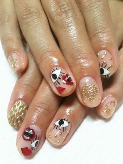natural bare nails with gold nail polish and elements of halloween with vampire teeth and eyes