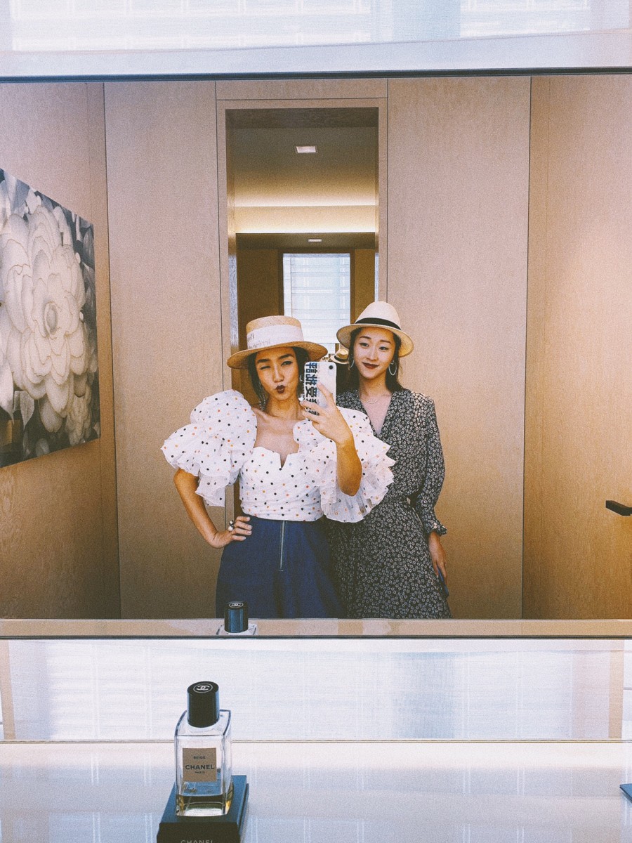 Two girls posing for a photo in front of the mirror