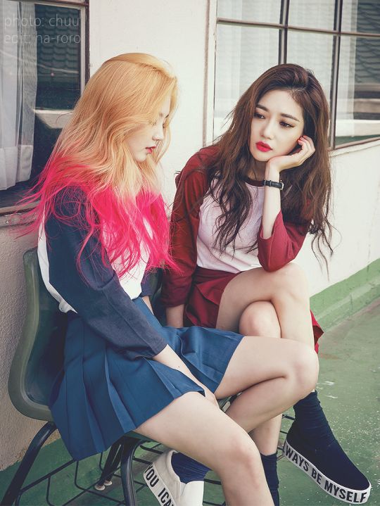 two girls talking to each other and one has half blonde half pink hair