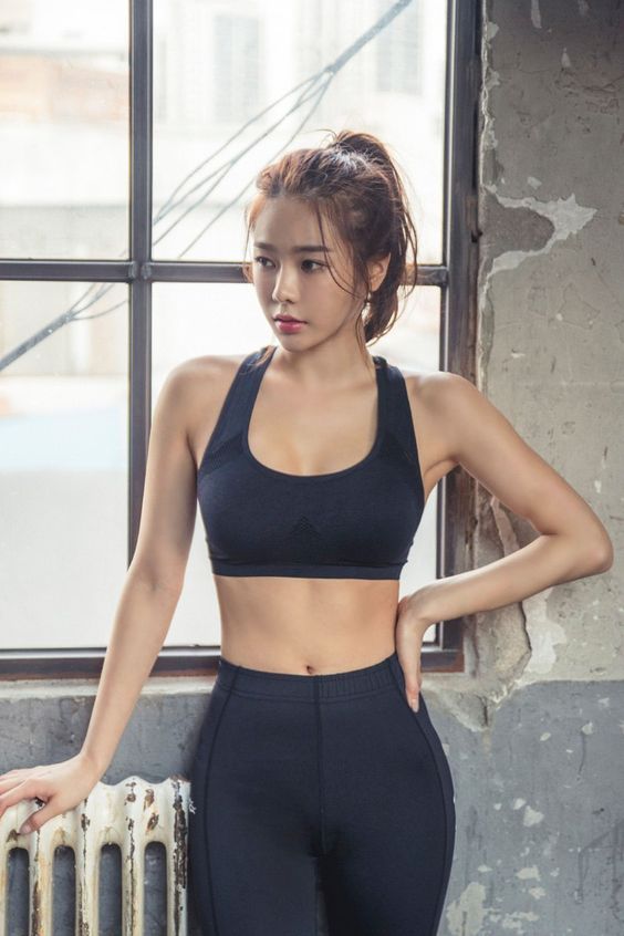 asian girl wearing a black sports bra and leggings