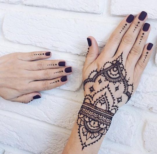 intricate and detailed henna art tattoo design on the back of the hand