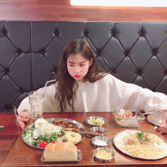 Korean girl looking at the spread of food on the table in front of her