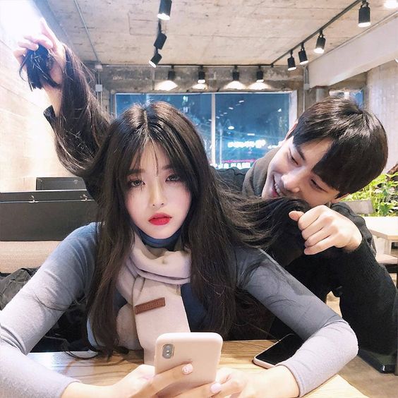 Boyfriend playing with girlfriend's hair at a cafe