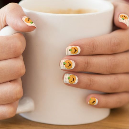 natural nail manicure with white base and a pumpkin on each nail