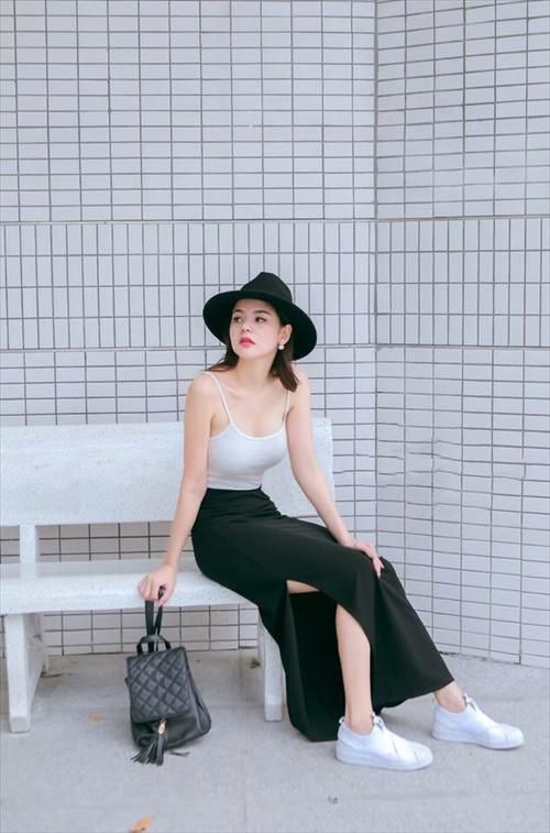 asian woman wearing a white top and black skirt