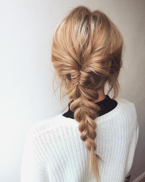 girl with light brown hair tied into a fishtail braid