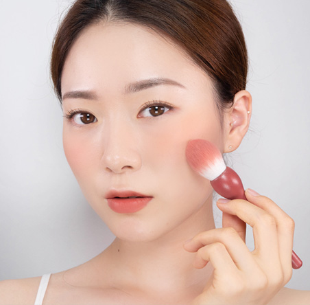 innisfree model applying blush using fig brush