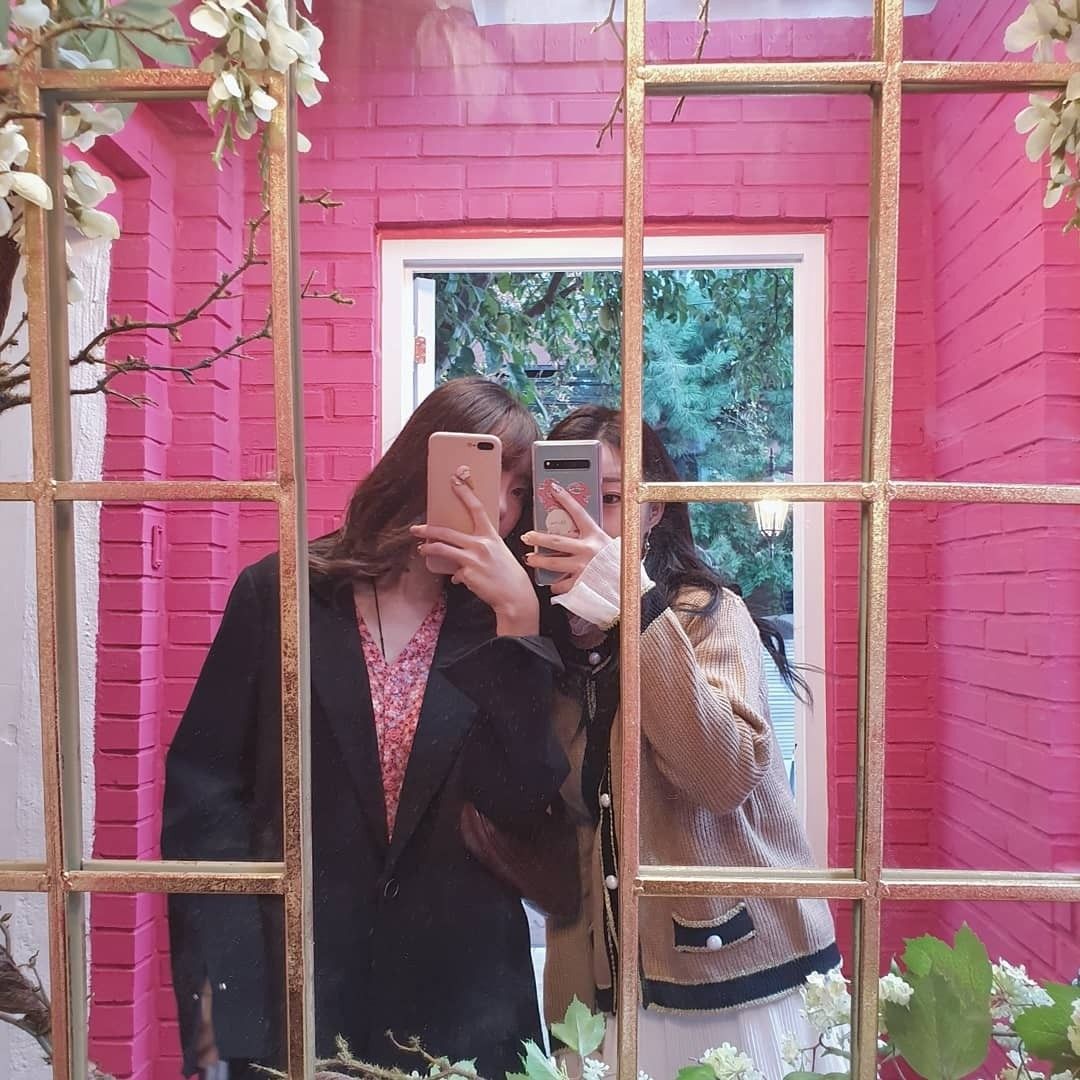 two girls selfie with pink background