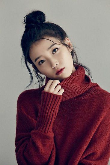 korean girl with her hair in a bun and wearing a dark red sweater