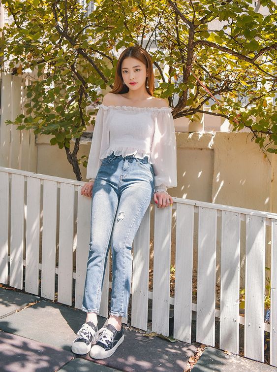 asian woman wearing a white off shoulder top and jeans