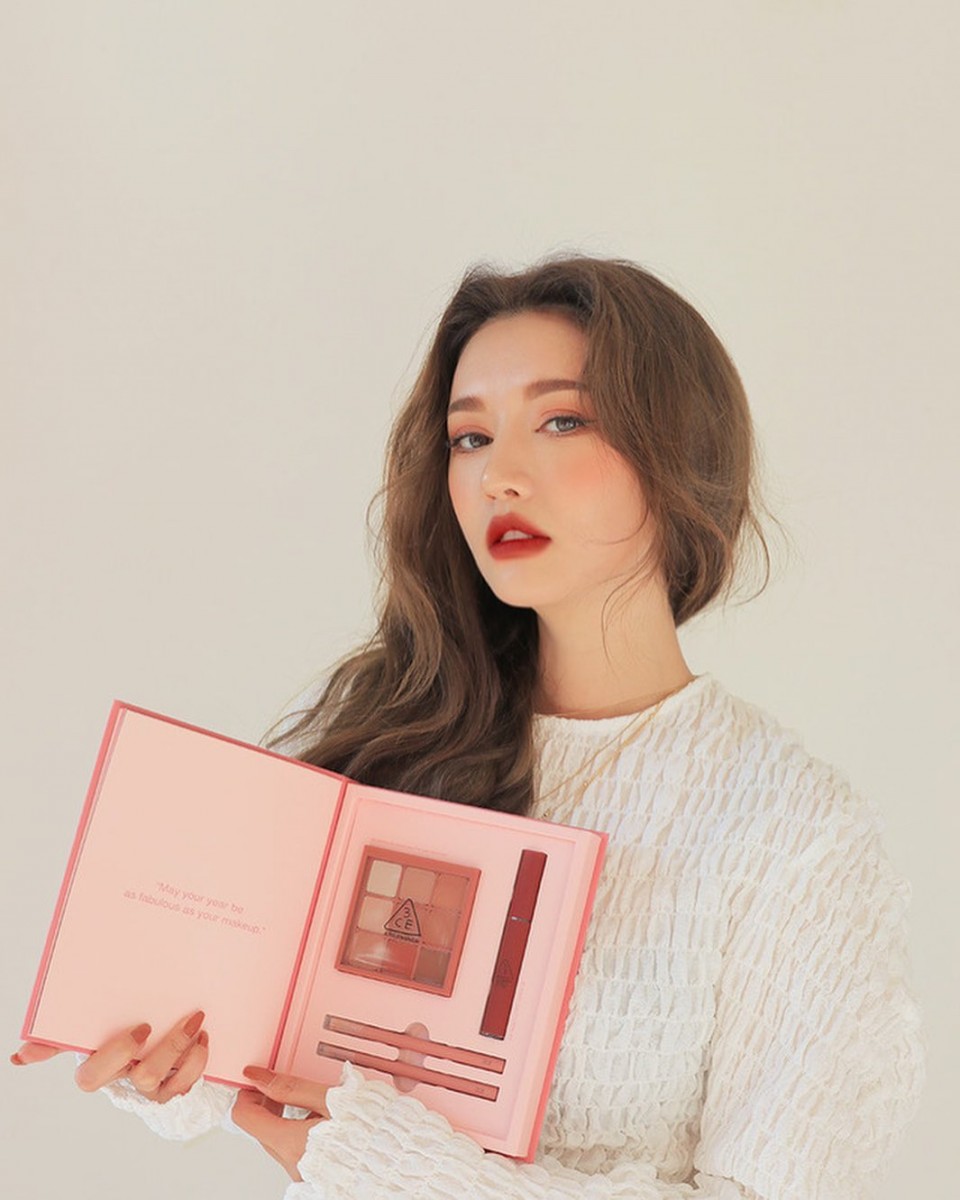 girl holding 3ce holiday book