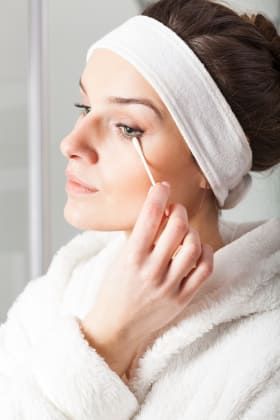 Using a cotton bud to remove eye makeup