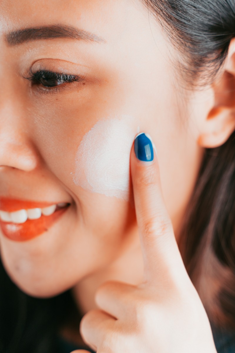 Model applying serum on cheek