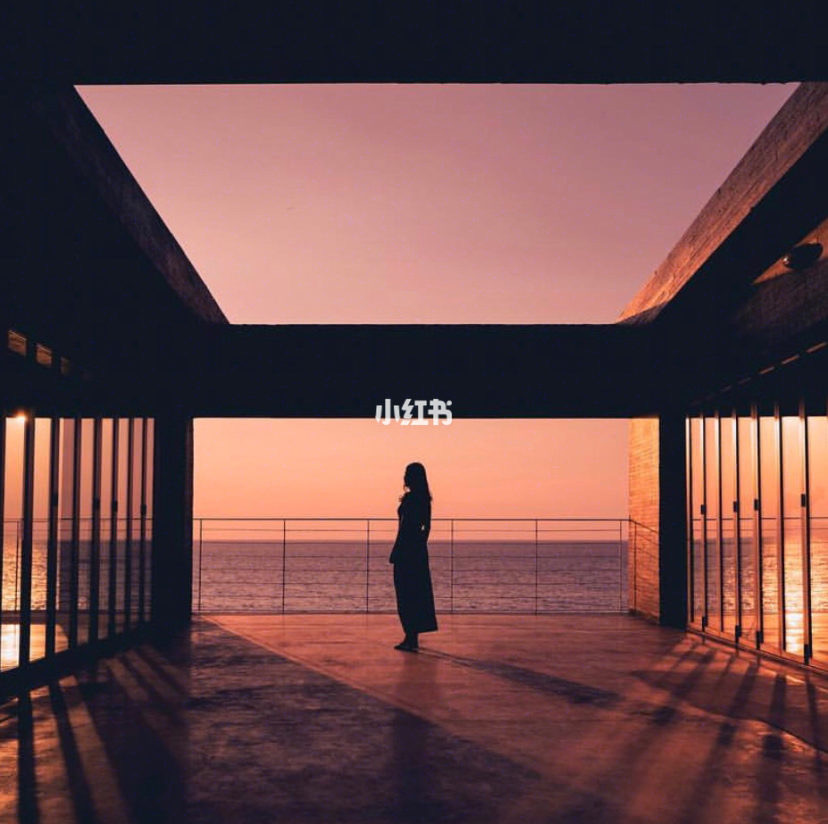 Girl alone looking out to the sea with purple skies