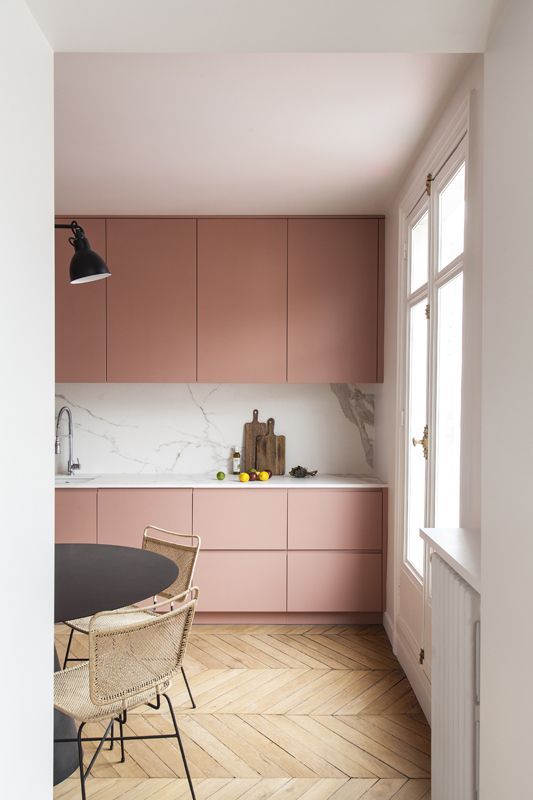 pink and white kitchen with wooden flooring