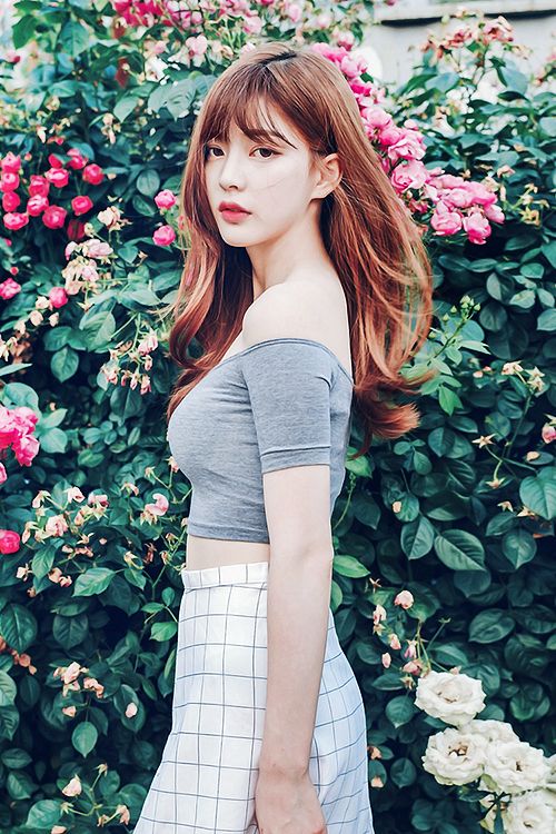 korean girl with voluminous hair standing in front of plants