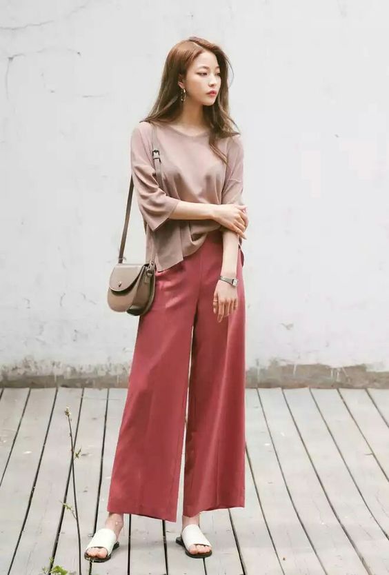 asian woman wearing a beige top and orange pants