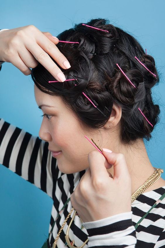 Girl twisting hair and securing with bobby pins