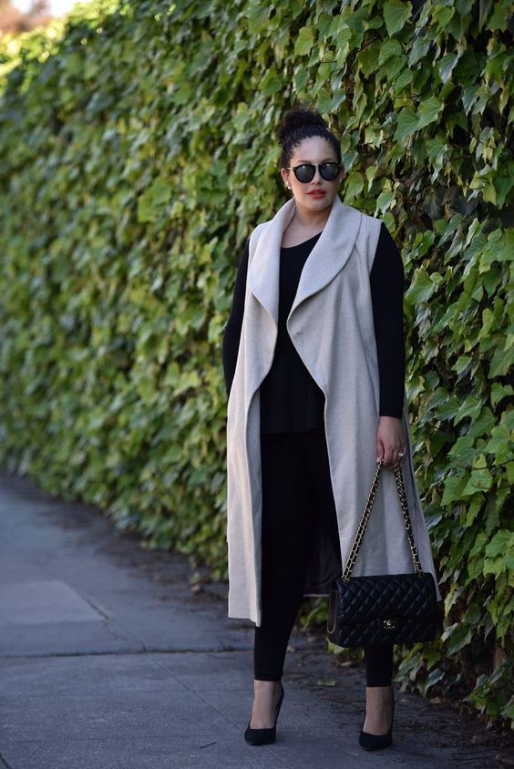  woman wearing a black top and beige sleeveless vest