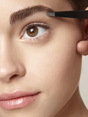 Girl tweezing her eyebrows