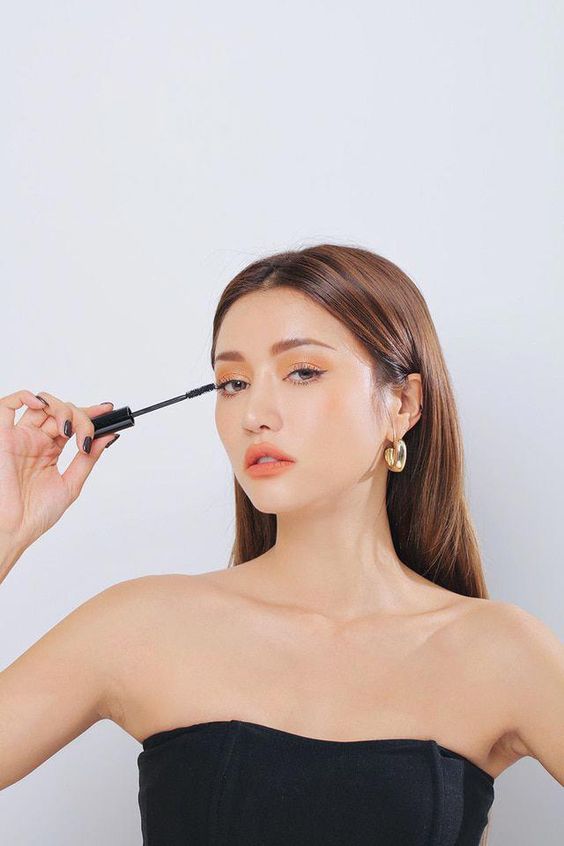 Model putting on mascara