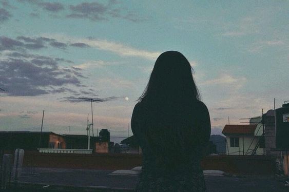 Back view of girl looking out into sunset