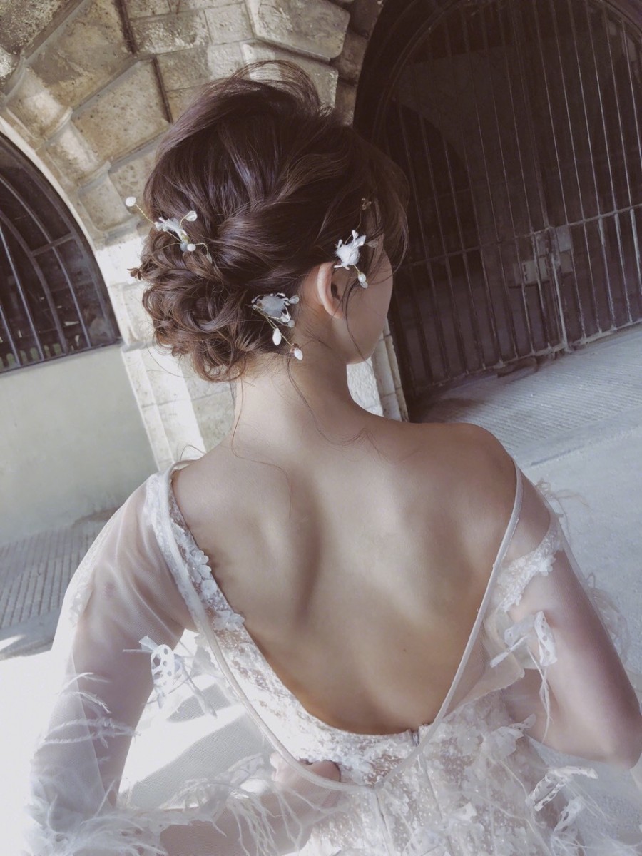 Curled and tied up hairstyle with white accessories