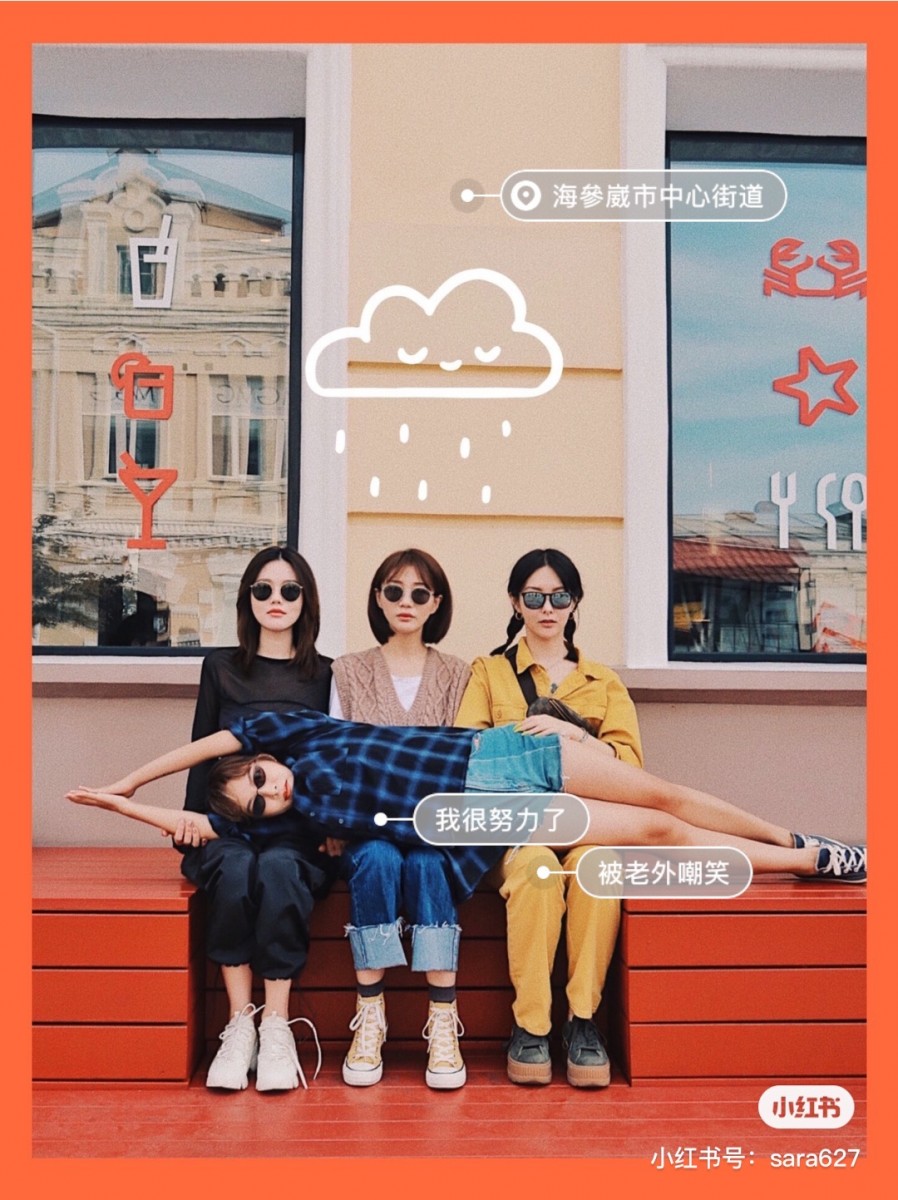 three girls sitting on a bench, one girl laying down