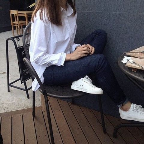 woman wearing white top, black jeans and white shoes