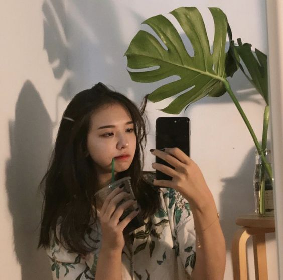 Girl taking selfie with plant in the background