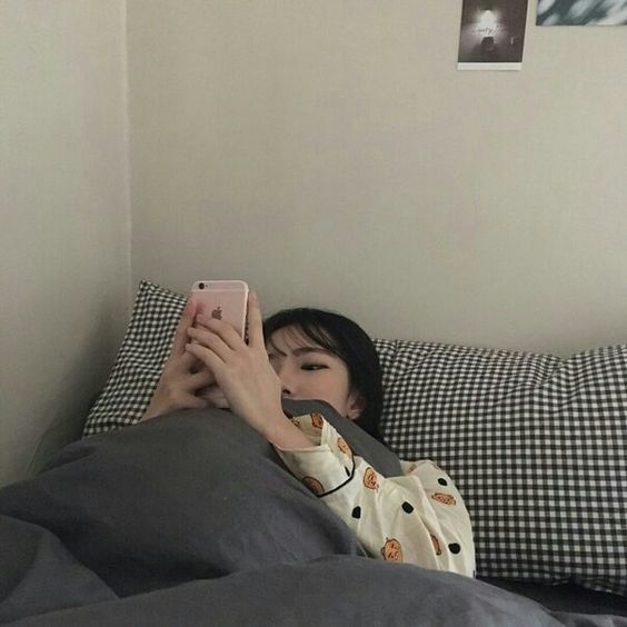 Girl laying in bed using phone