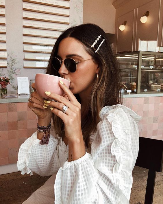 Girl drinking coffee with hair clips in her hair